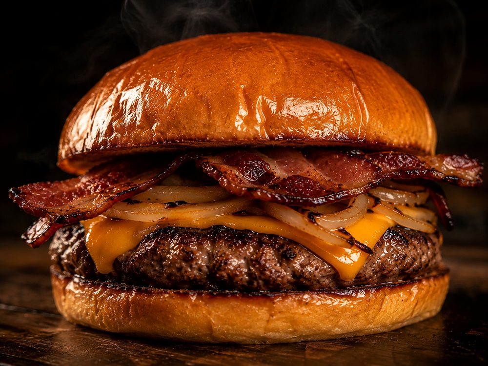 Hambúrguer da Bullgers com fatias de bacon, cebola grelhada e cheddar