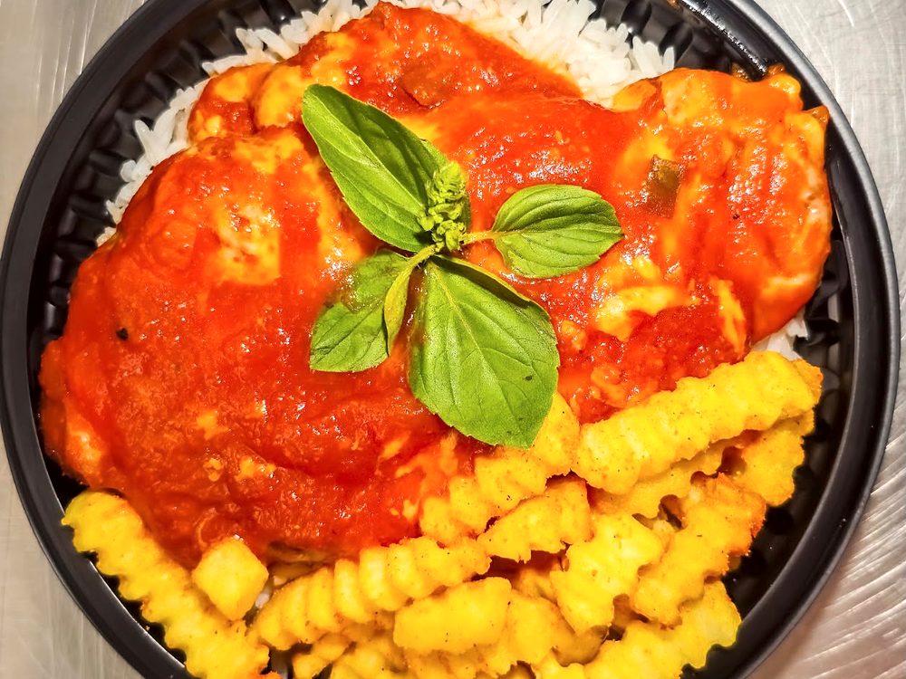 Parmegiana com molho de tomate e manjericão, arroz e batata frita ondulada, vista de cima
