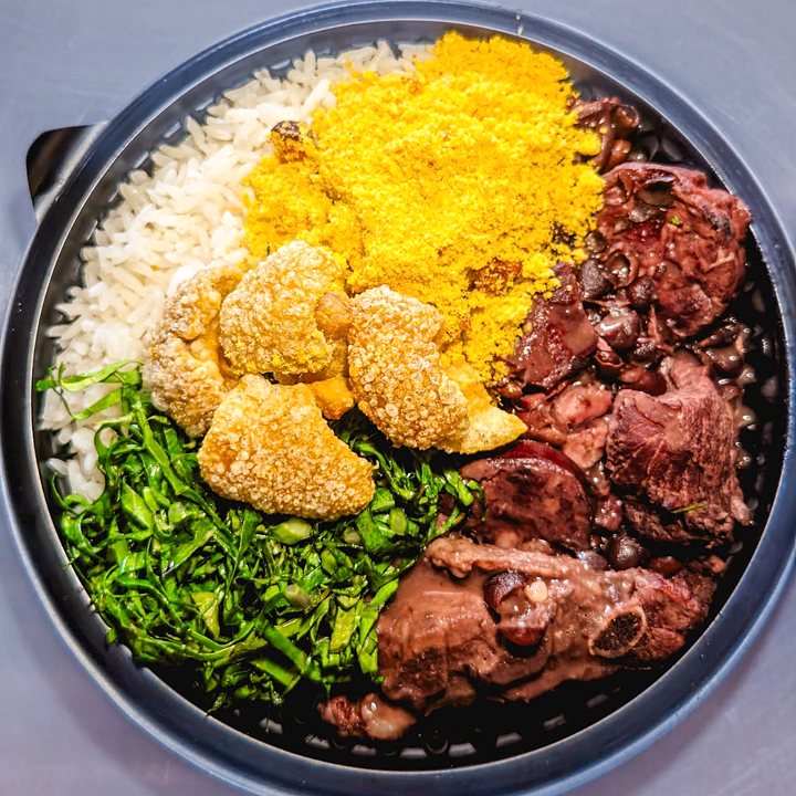 Feijoada na tigela, com arroz, farofa, torresmo, couve e carnes