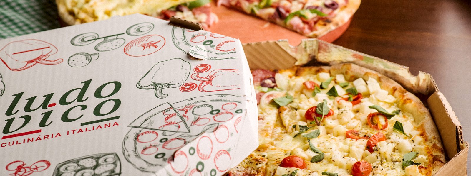 Caixa de pizza da Ludovico Culinária Italiana aberta, com a pizza dentro