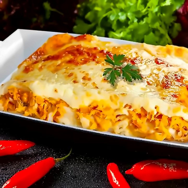 Lasanha gratinada na travessa branca, com pimentas ao redor